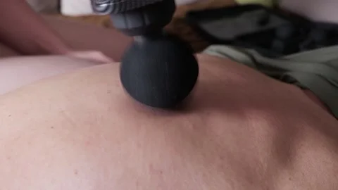 Percussion Massage Gun Massaging Sore Back Muscles During Home Recovery Session Stock Footage 335230183