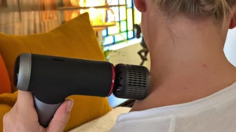 Percussion massage gun on neck muscles in close up Stock Footage 340165183