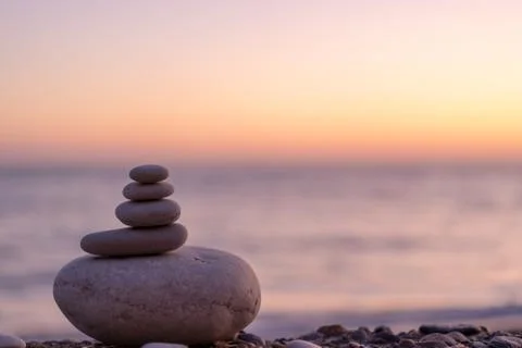 Perfect balance of stack of pebbles at seaside towards sunset. Concept of bal Stock Photos