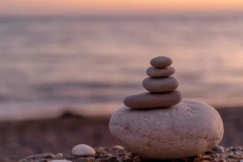 Perfect balance of stack of pebbles at seaside towards sunset. Stock Photos