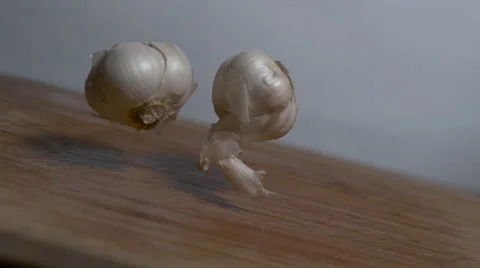 Perfect Cloves of garlic falling in slow motion onto a cutting board Stock Footage 64671550