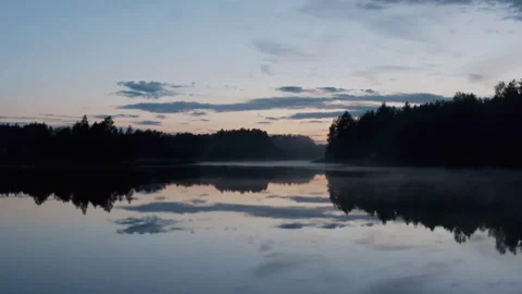 Perfect forest reflections on still lake water at dusk Stock Footage 333830025