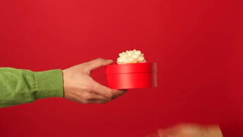 Perfect gift. Close up of hands of guy giving a gift with ribbon to his Stock Footage 146127201