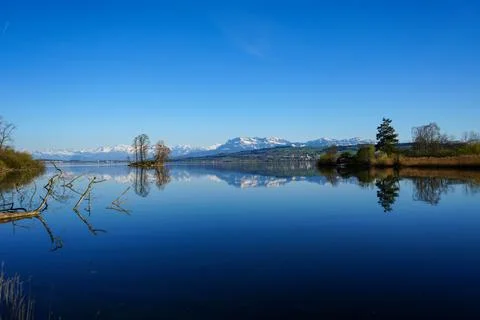 Perfect Lake Reflection of Alpine Mountains Under Clear Blue Sky Foto stock