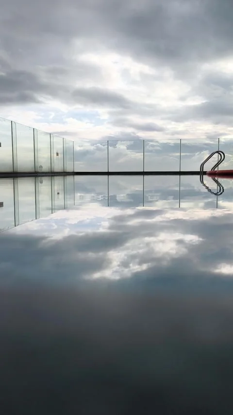 Perfect Mirror Reflection of Cloudy Sky in Calm Pool Stock Footage 321890881