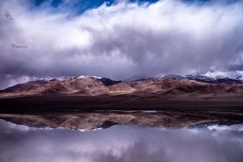 Perfect mirror reflection of snow-dusted mountains on Laguna Diamante lake .. Stock Photos