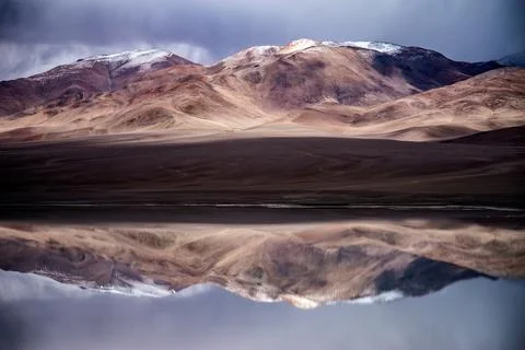 Perfect mirror reflection of snow-dusted mountains on Laguna Diamante lake .. Stock Photos