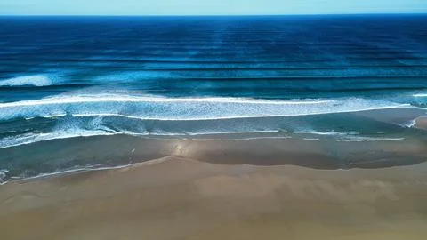 Perfect Ocean Waves Rolling Onto Remote Sandy Beach Stock Photos