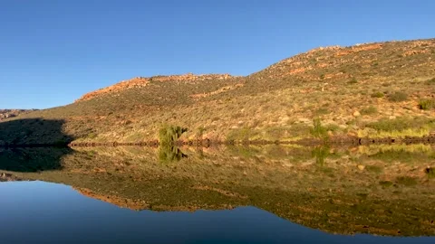 Perfect reflection of mountains in still dam waters Stock Footage 189980977