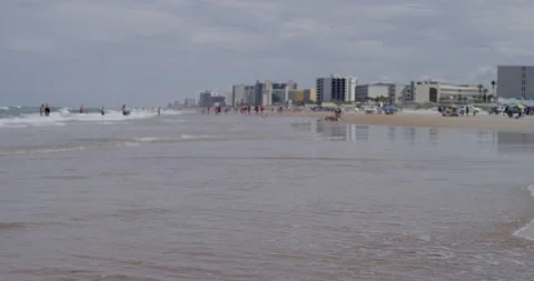 A perfect sandy beach view with ocean waves, people and buildings Stock Footage 150642602