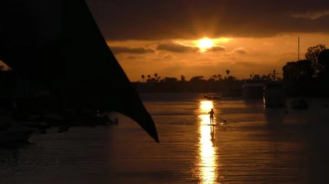 Perfect shot of Stand up paddle boarder floating into amazing golden sunset i Video stock 67490192