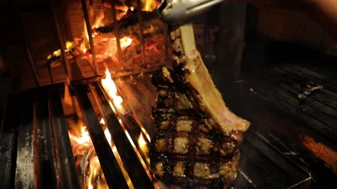 Perfect T-bone steak roasted on a grill, turned on the other side, cooking. Stock Footage 202021431