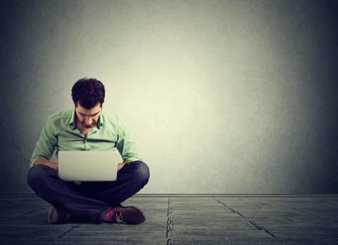 Perfect technology. Man sitting on floor working on laptop computer Stock Photos