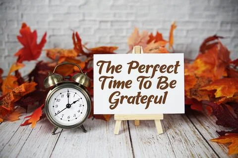 The Perfect Time To Be Grateful text with alarm clock and maple leaf decora.. Stock Photos