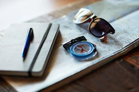 The perfectly planned trip. Shot of a map and adventure gear arranged on a ta Stock Photos