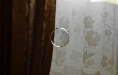 Perfectly round transparent soap bubble on a brown and white background Foto stock
