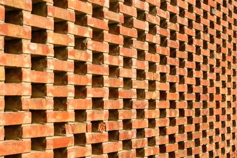 Perforated brick wall with geometric pattern and urban design. Stock Photos