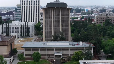 Perforated concrete tower rises above municipal building with flat roof, dense Stock Footage 337746573