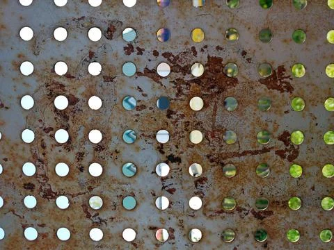 Perforated Metal Wall Showcasing Texture, Rust, and Reflections From a Vibr.. Stock Photos