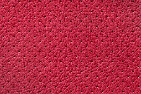 Perforated red leather texture background, closeup. Dark backdrop from wrinkl 스톡 사진