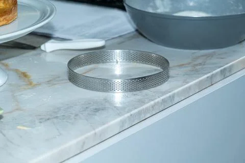 Perforated ring for baking pies on the marble countertop. Stock Photos