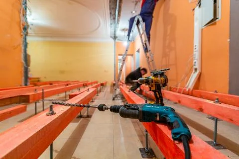 Perforator with long bore bit and screw gun are in apartment that is under Stock Photos