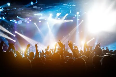 Performace of a popular group. Crowd is dancing and having fun. Bright spotli Stock Photos