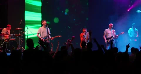 Performance of a pop or rock group, music band on stage. Stage neon light and Stock-Footage 195544689