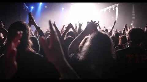 Performance of a popular group. The crowd with raised hands against the stage li Stock Footage 272481597