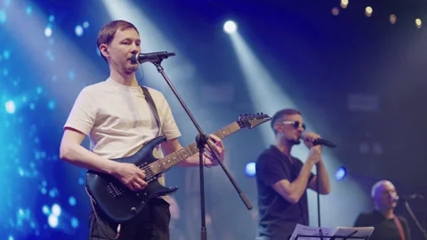 Performance of popular pop group on stage of nightclub. Vocalist and two backing Stock Footage 243766066