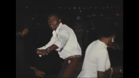 Performer dancing tribal dance in stage to entertained astronaut - 1969 Stock Footage 104332388