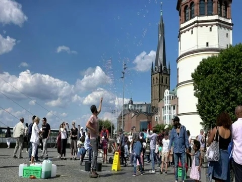 Performer making bubbles to entertain people at Dusseldorf historic center Stock Footage 85128114