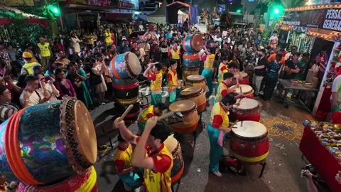 Performer plays Chinese drums as devotees pass by during Thaipusam. Vídeo Stock 317005839