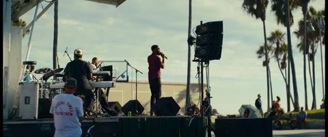 Performer in Red Holds a Microphone on an Outdoor Stage Stock Footage 344814972