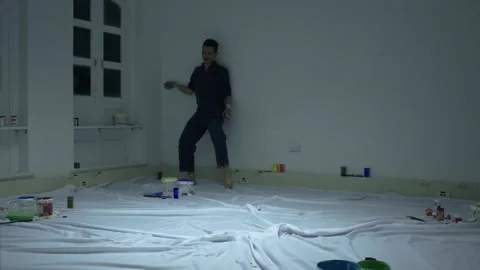 Performing art of a man dancing around planning a shower of colored paint. Stock-Footage 255599709