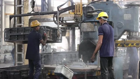 Performing crucial sand casting operations on a dusty production line Stock Footage 320934884