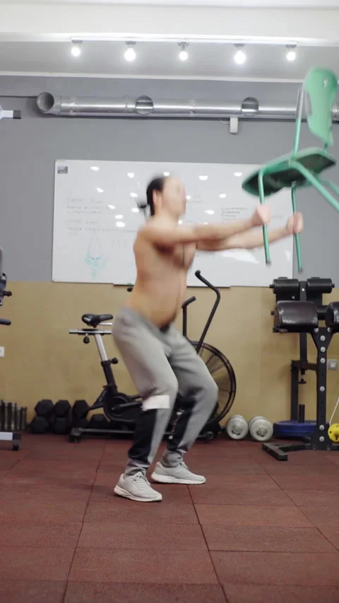 Performing a Dynamic Squat Exercise with a Chair for an Effective Full Body Stock Footage 308929414