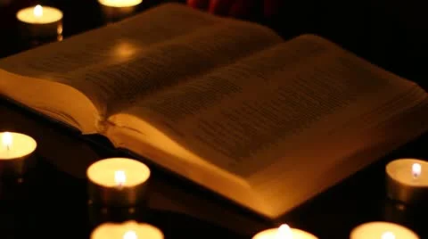 Performing occult magic or just reading a book in the light of candles Stock Footage 12140147