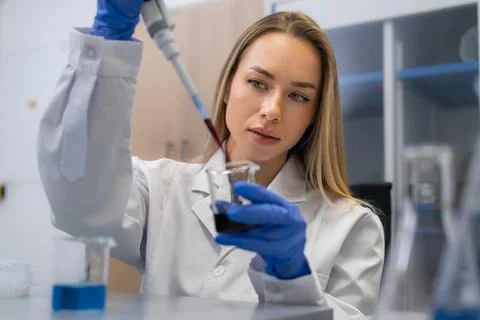 Performing precise sample transfer with pipette using dark biological liquid in Foto stock