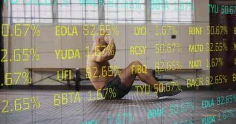 Performing shirtless man doing situps on gym floor wearing dark shorts and Stock Photos