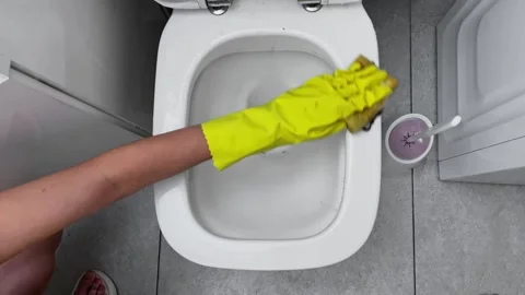 Performing the task of cleaning a toilet requires the use of rubber gloves and Stock Footage 282726978