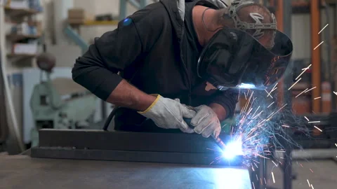 Performing a weld: the man in the welding mask is positioned with the welding Stock Footage 276085310