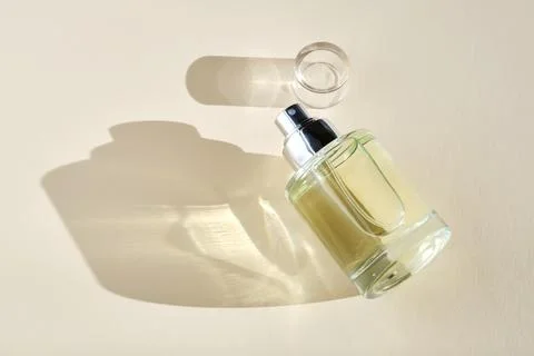 Perfume on a beige background in the rays of bright sun with beautiful high.. Stock Photos