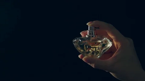 Perfume on black background. Splash of eau de toilette Vídeo Stock 76709419