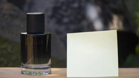 Perfume Bottle With Blank Sticky Note On Wooden Plank Stock Photos
