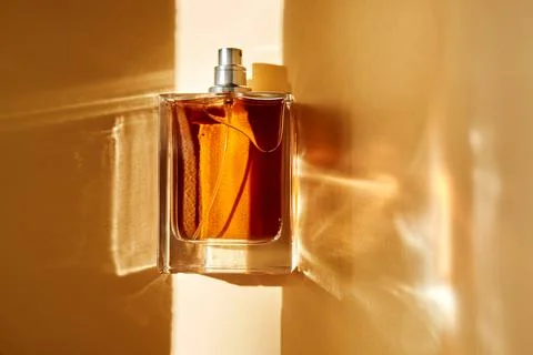 Perfume bottle capturing sunlight and casting shadows Foto stock