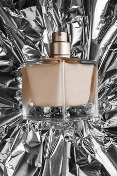 Perfume bottle on foil Stock Photos