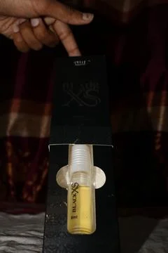 Perfume bottle in packaging with hand on box 스톡 사진