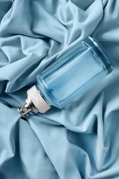 Perfume on draped fabric Stock Photos