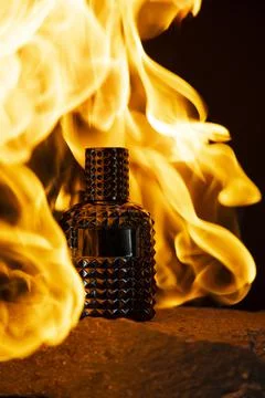 Perfume fire bottle. Mockup on the dark or black empty background. Stock Photos